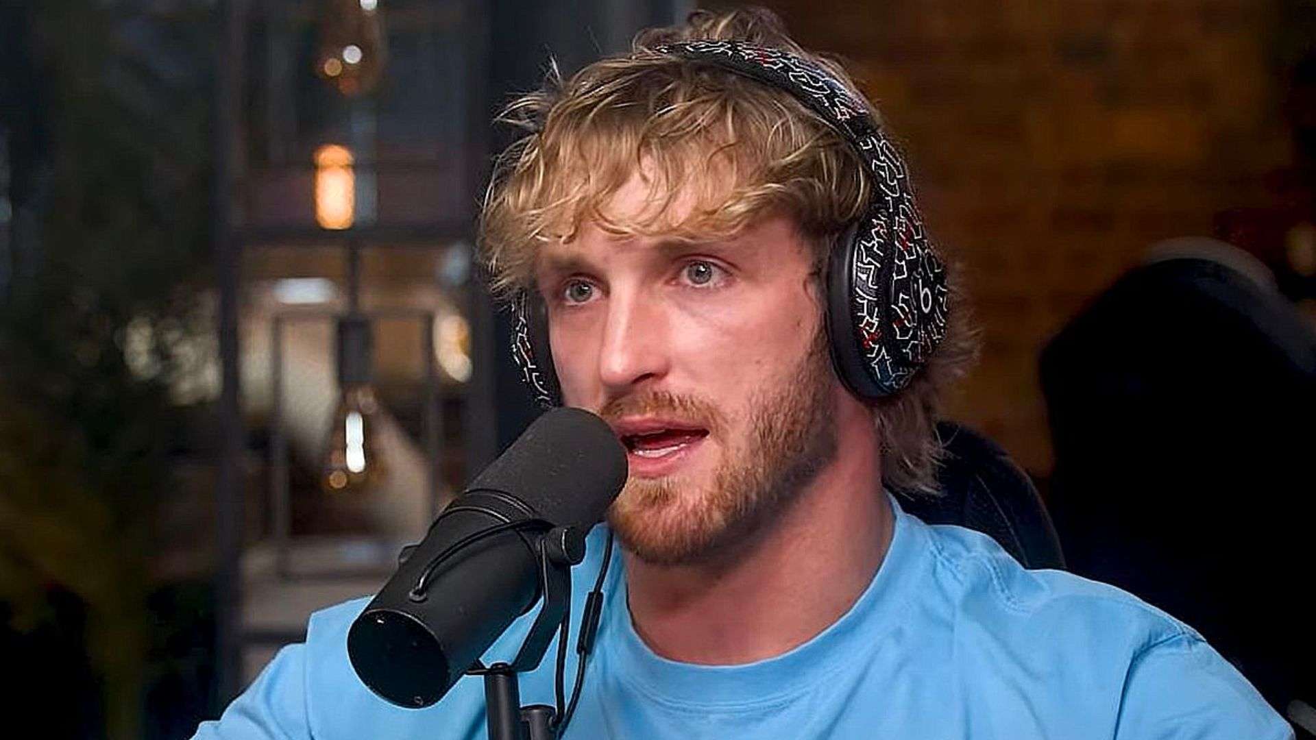 Logan Paul talking into mic in blue shirt