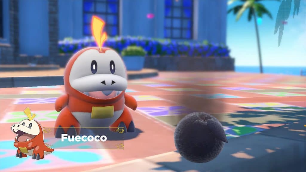 Fuecoco, a fire-type starter in Pokemon Scarlet and Violet sitting next to a burnt fruit