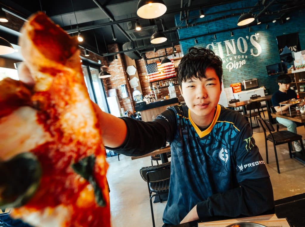 Jojopyun holding up pizza at camera in Evil Geniuses jersey