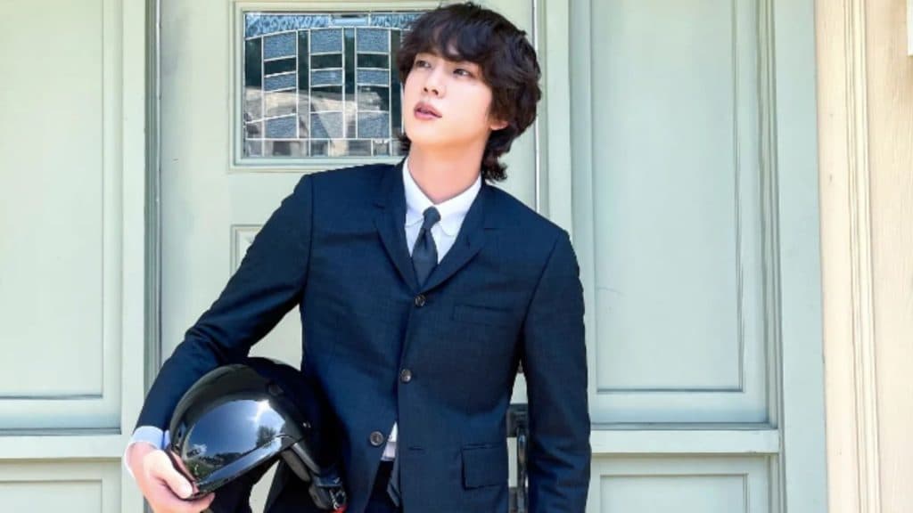 BTS member Jin posing with a helmet