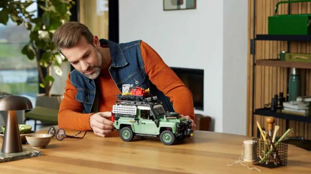 Adults admire the LEGO Icon Land Rover Classic Defender 90 set.