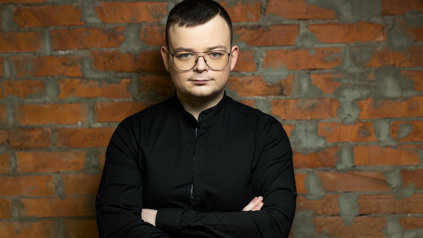 Man standing with back on brick wall