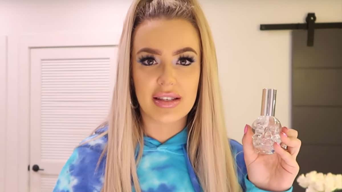 Tana Mongeau holding her TANA by Tana perfume bottle