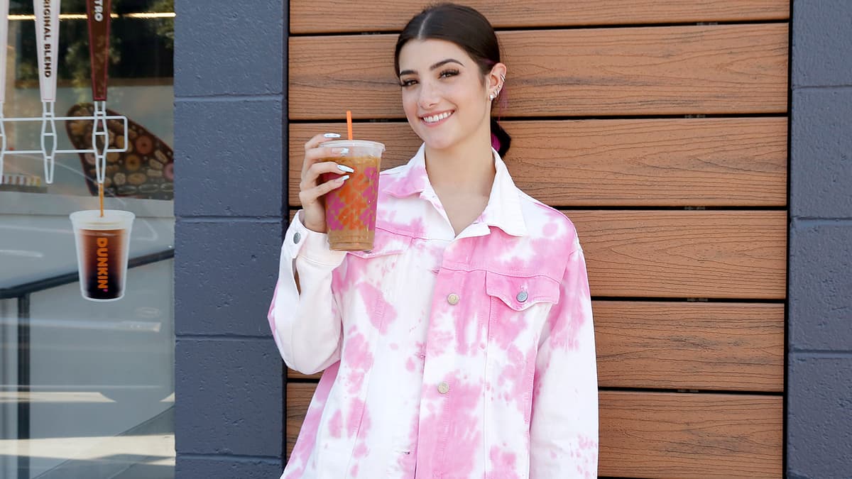 Charli D'Amelio poses with her own signature Dunkin' Donuts drink.