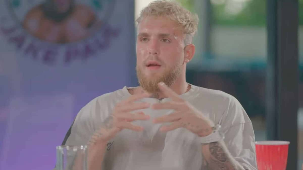 Jake Paul taking to camera with red cup and purple background