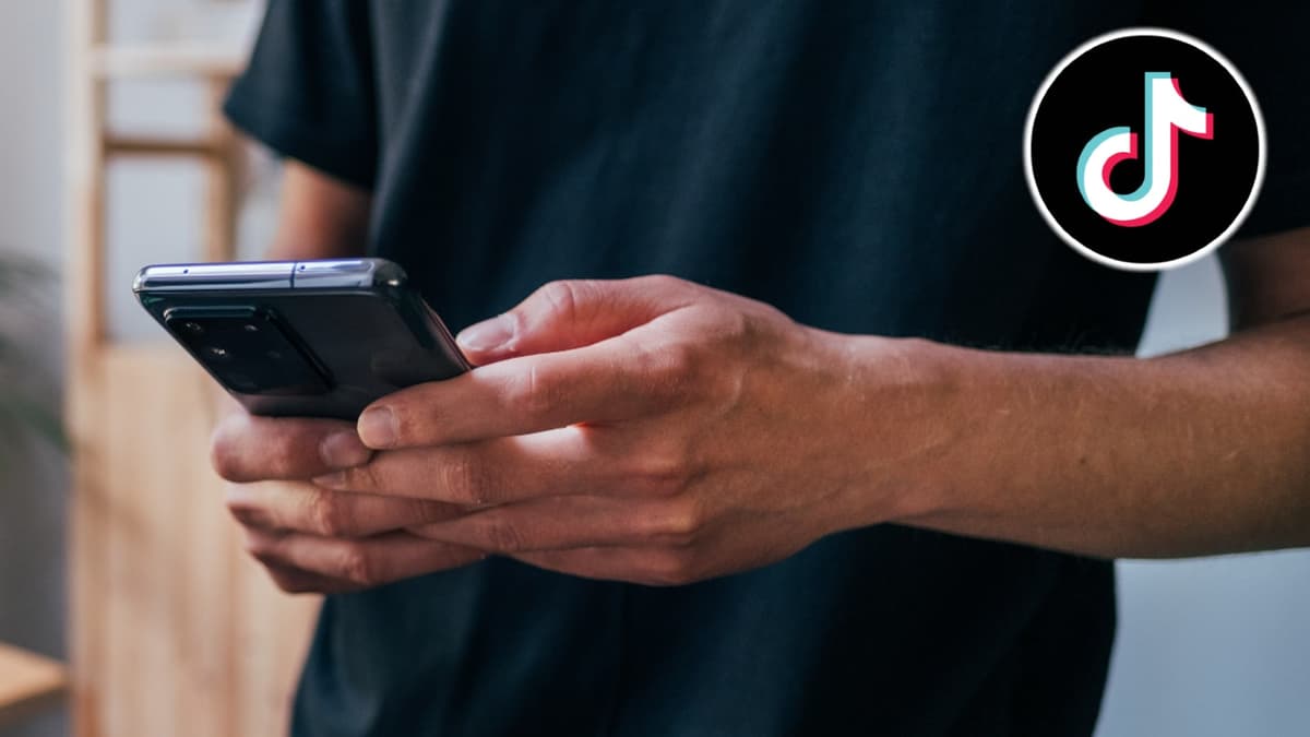 TikTok logo next to man holding phone