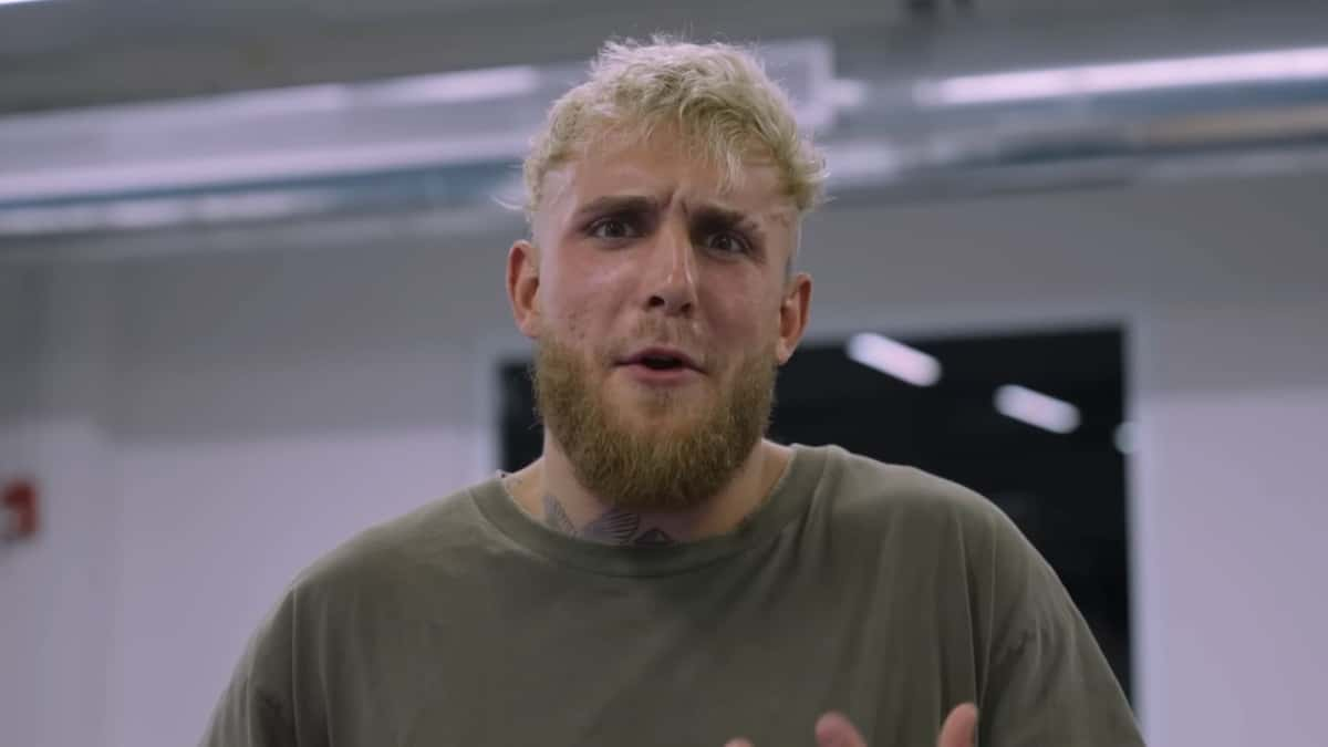 Jake Paul talking to camera in green shirt and white background