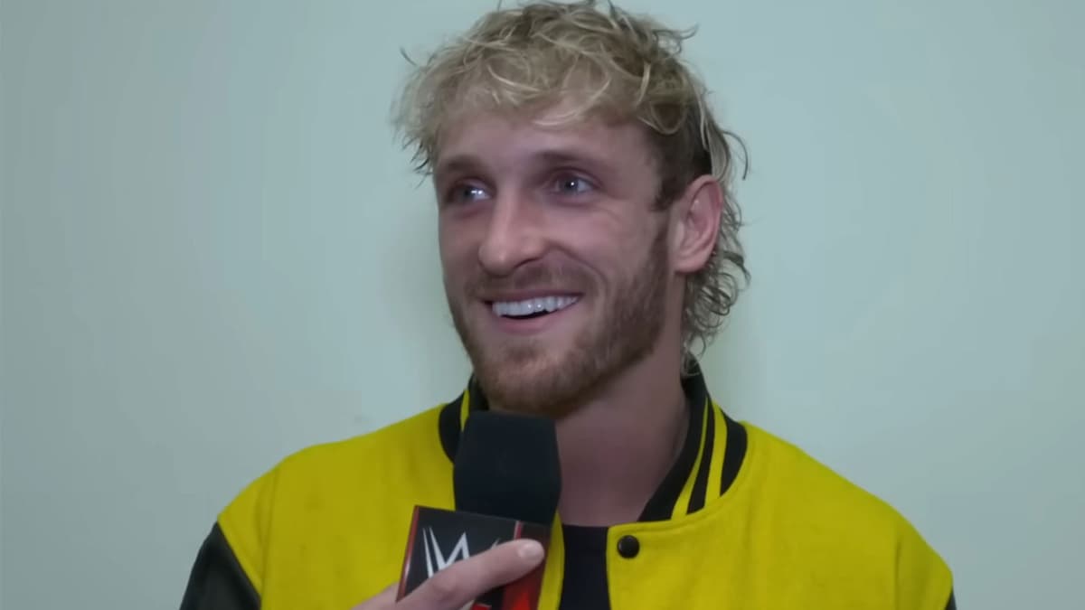 Logan Paul wearing yellow Maverick jacket holding WWE microphone