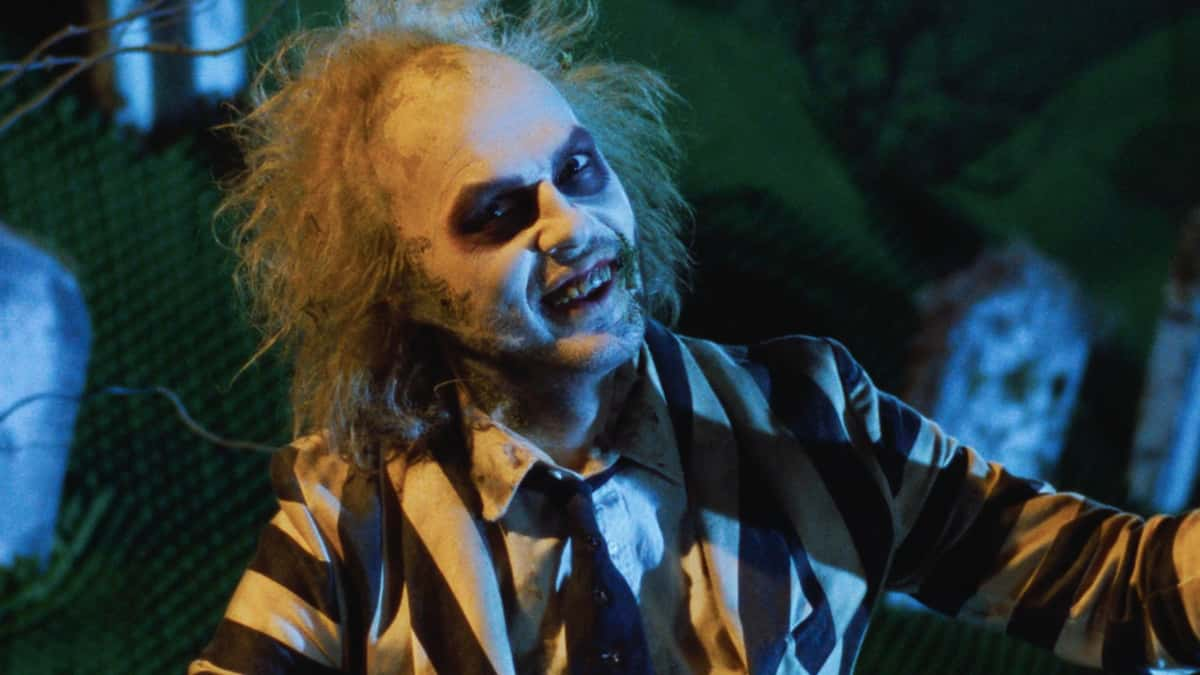 Michael Keaton as Beetlejuice wears a striped suit in a graveyard in Beetlejuice