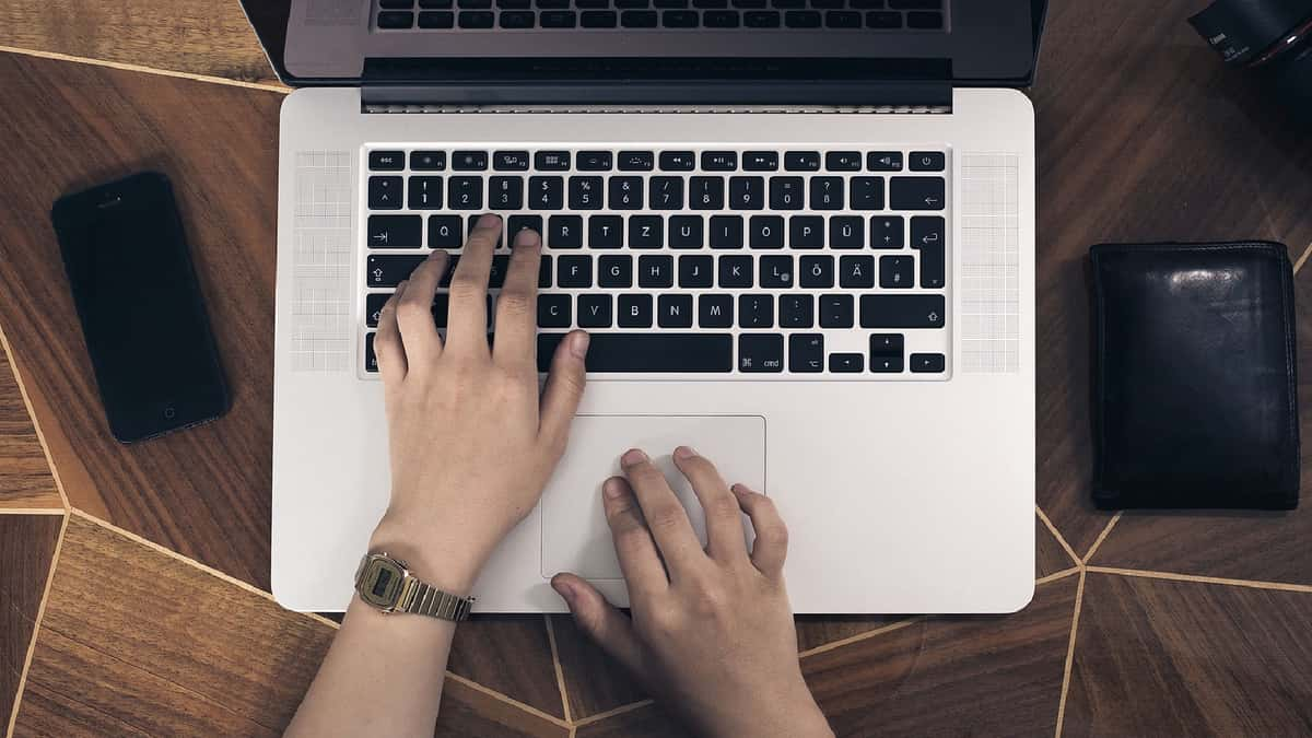 Someone typing on a MacBook's keyboard