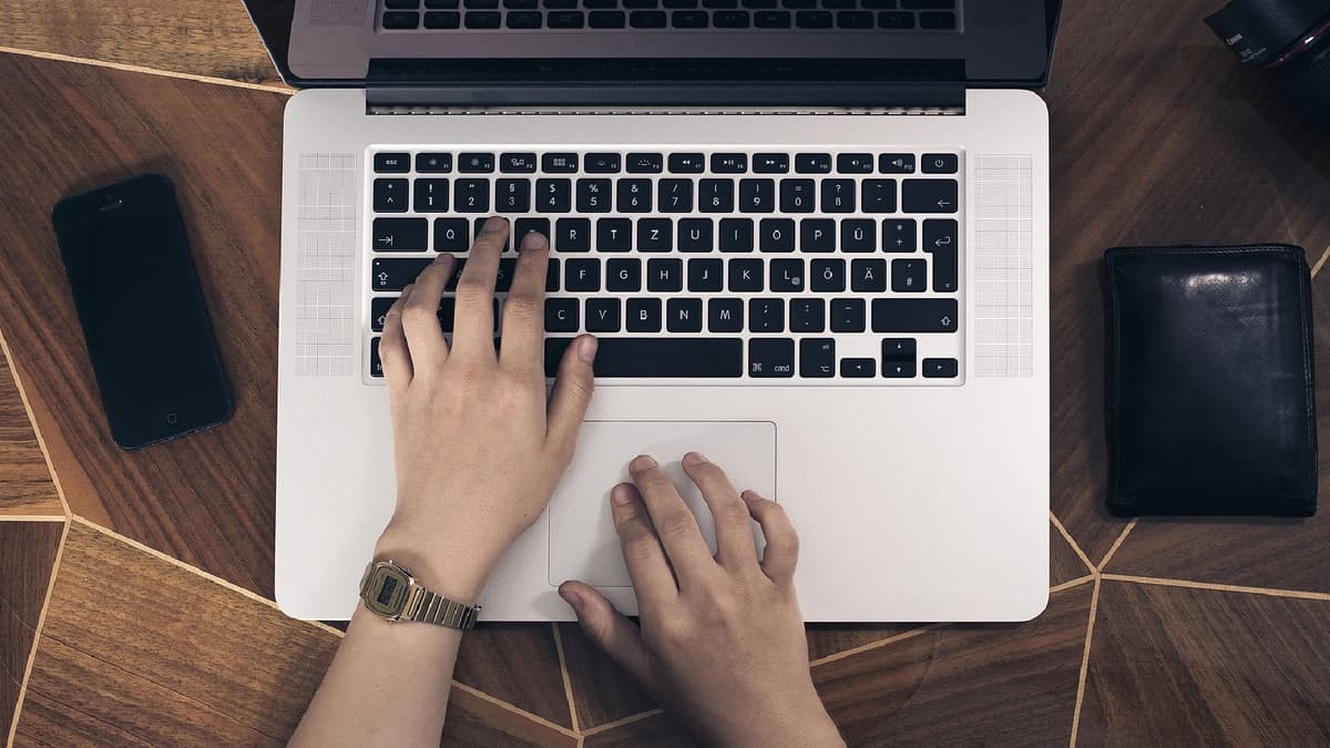 Someone typing on a MacBook's keyboard