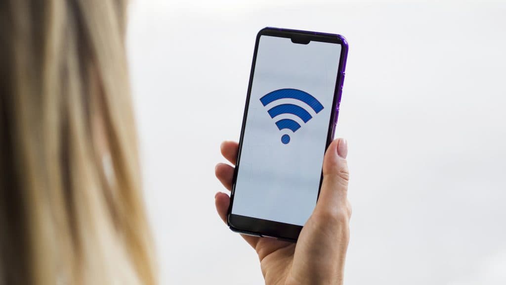 A woman holding an Android phone with Wi-Fi icon showing up