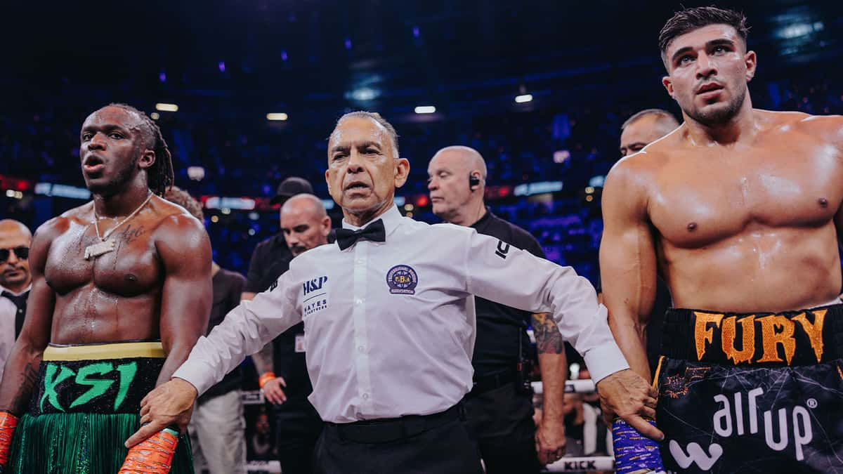 Referee inbetween KSI and Tommy Fury in boxing ring after fight