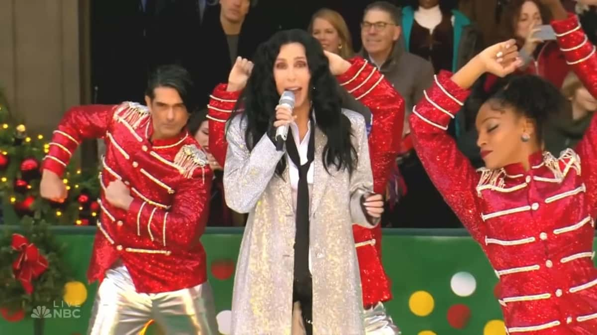 Cher in a jacket performing outside at a concert