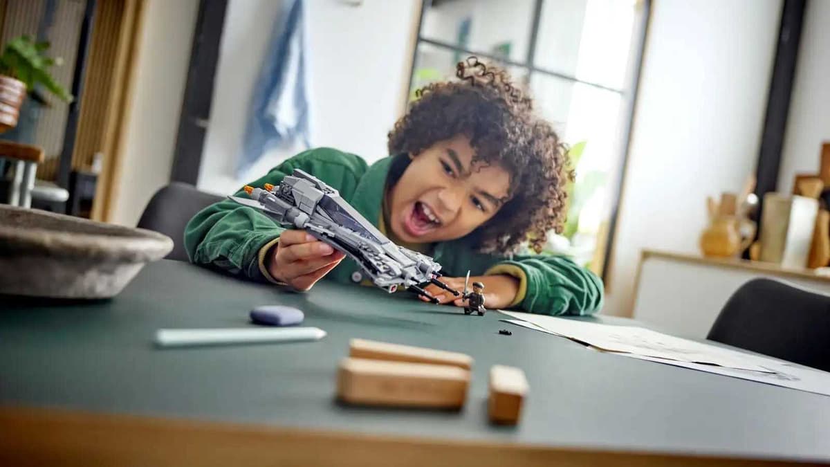 Child playing with a LEGO Star Wars set.