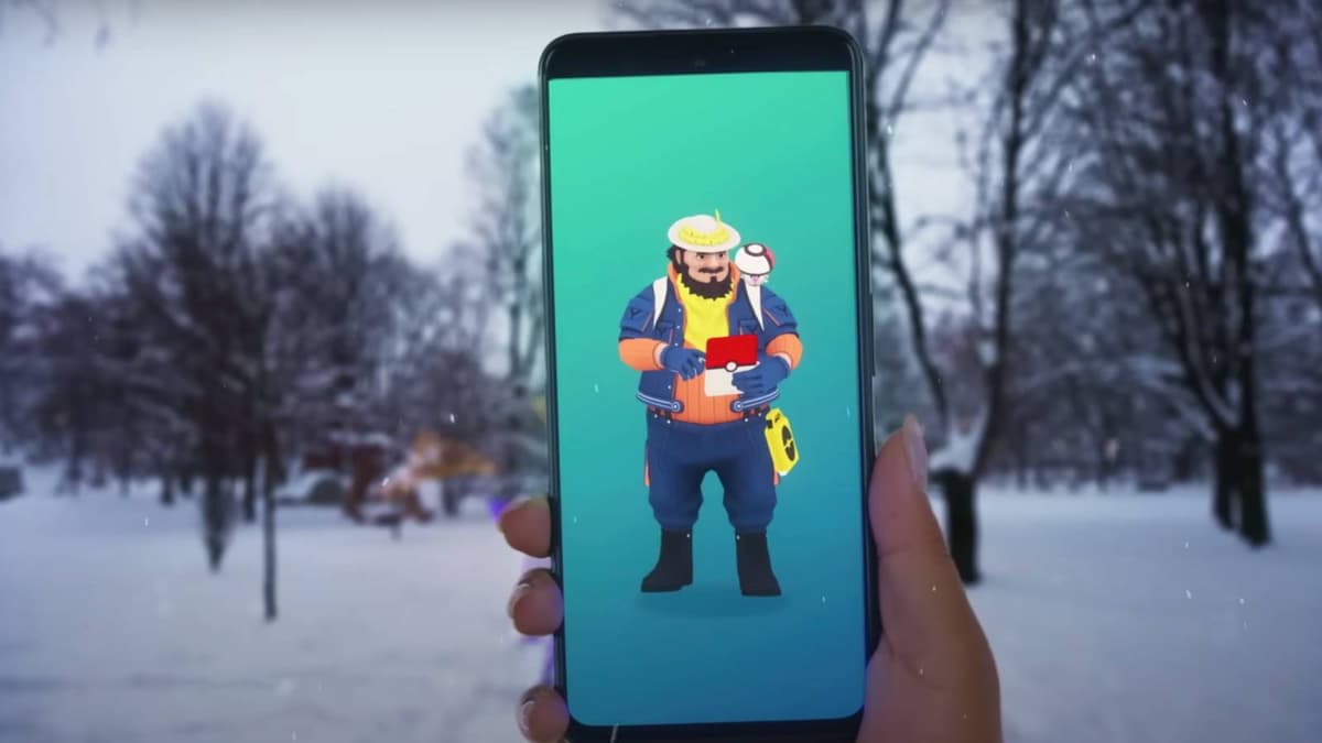 A Pokemon Go player holds up their phone in a snowy field, and the NPC Mateo is visible on the screen