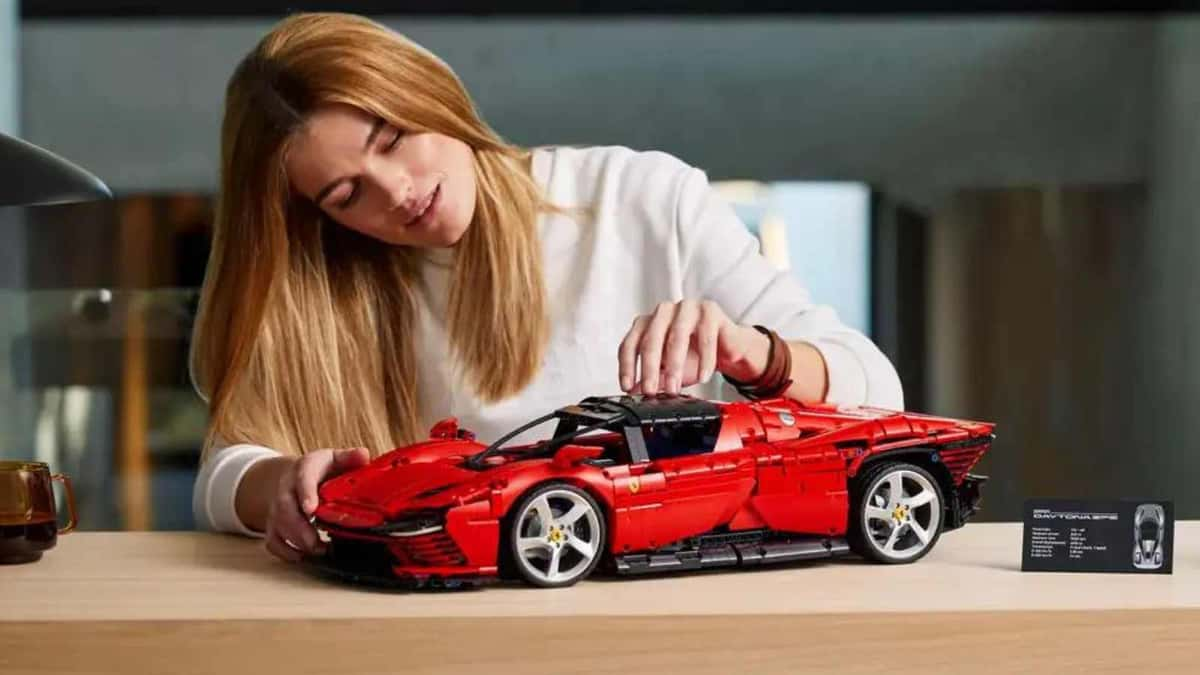 An adult admiring their LEGO Technic Ferrari Daytona SP3 set.