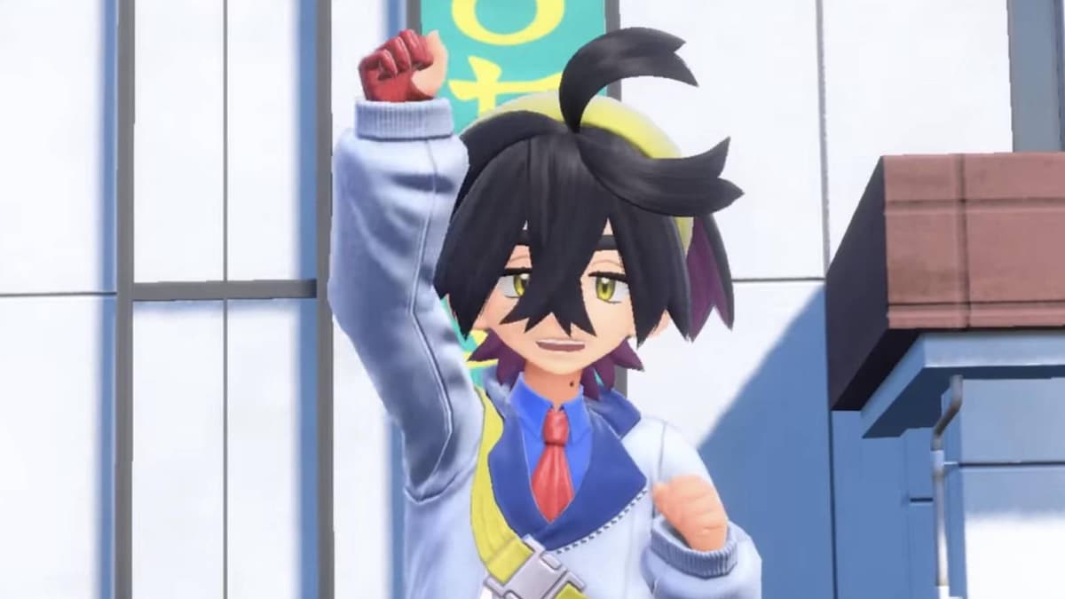 A screenshot from Pokemon Scarlet and Violet shows trainer Kieran lifting their right hand in the air triumphantly