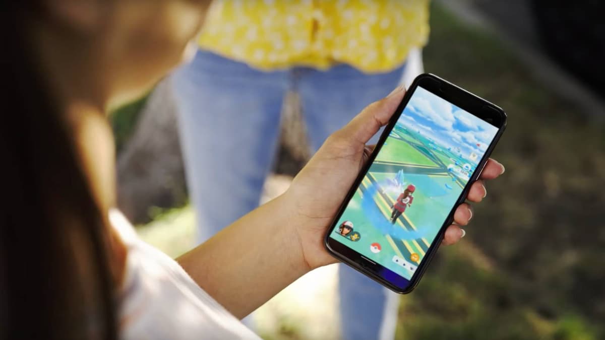 A person holds a phone with Pokemon Go visible on the screen