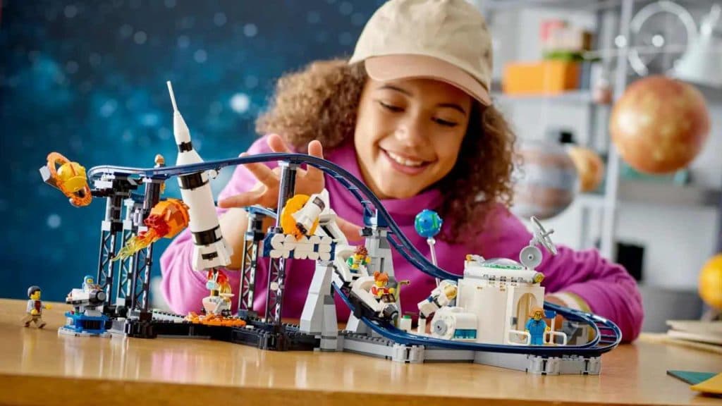 A child playing with their LEGO Creator 3in1 Space Roller Coaster set.