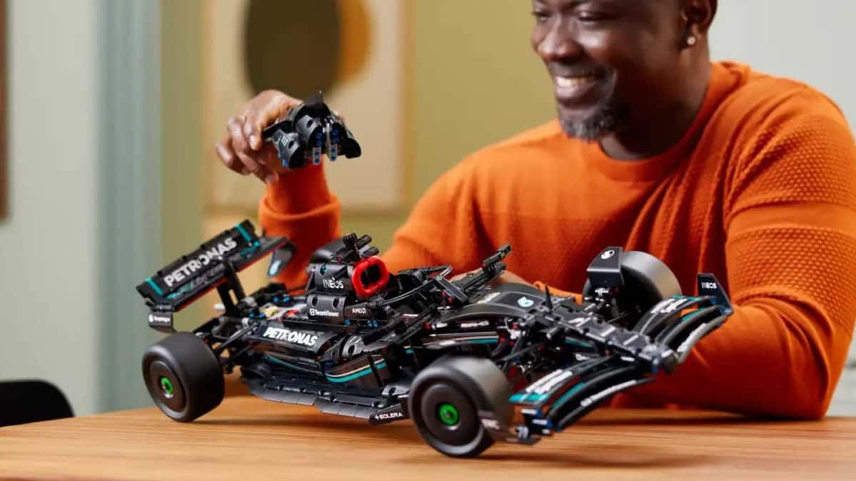 An adult with their LEGO Technic Mercedes-AMG F1 W14 race car set