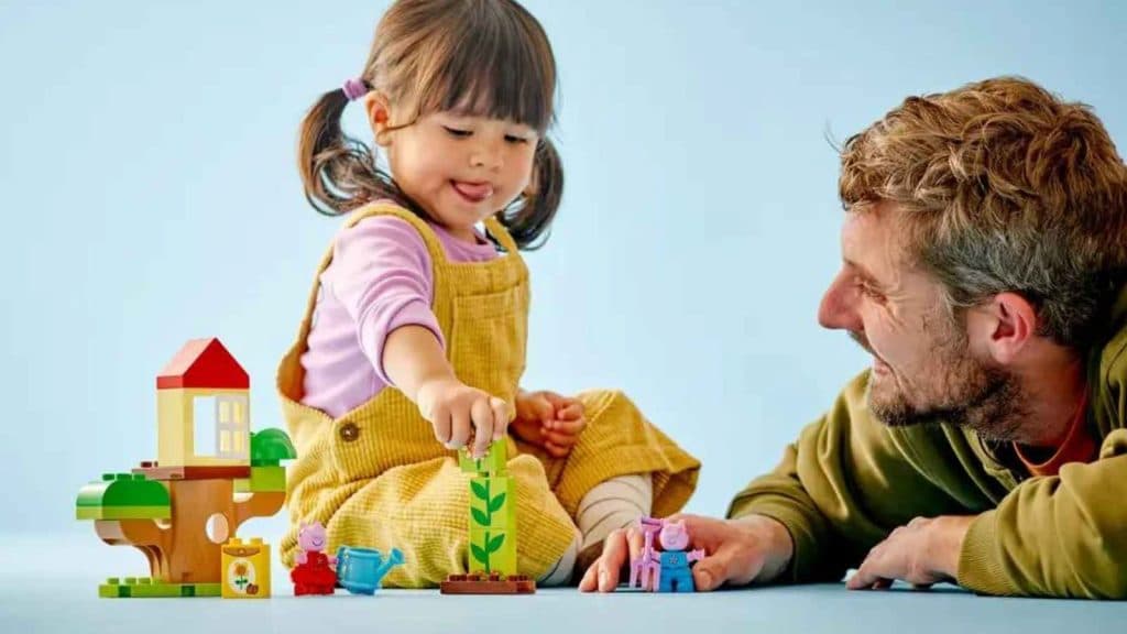 A child and an adult with the LEGO Duplo Peppa Pig Garden and Tree House set