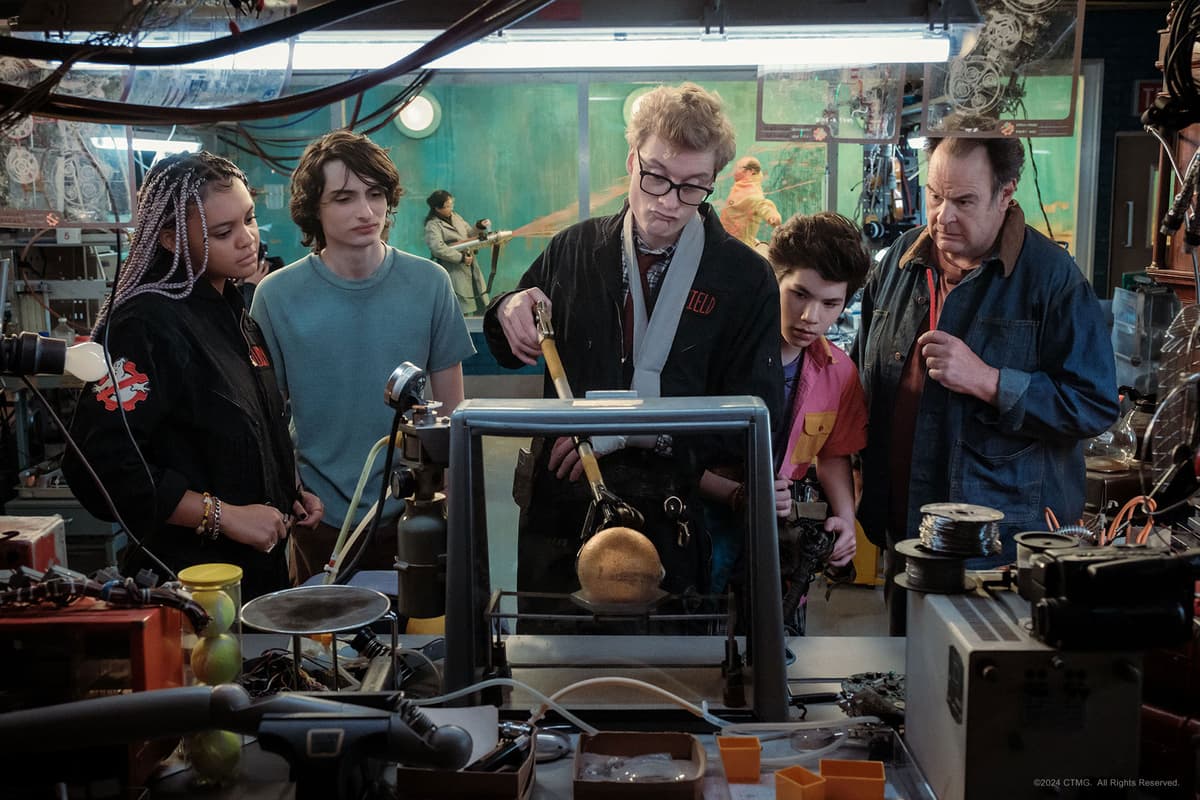 Characters in Ghostbusters Frozen Empire watch an experiment in a lab.