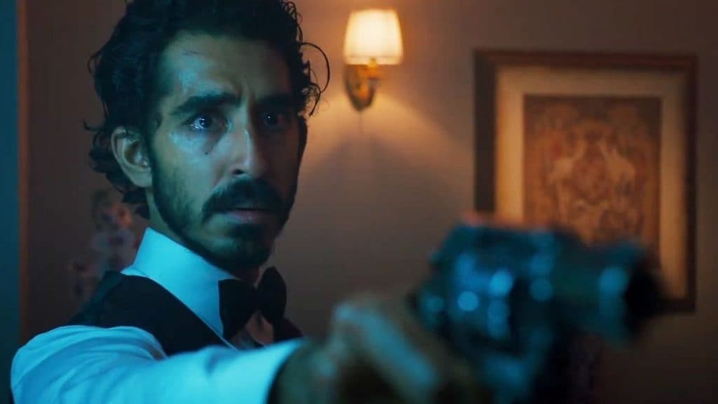 Dev Patel firing a gun in Monkey Man.