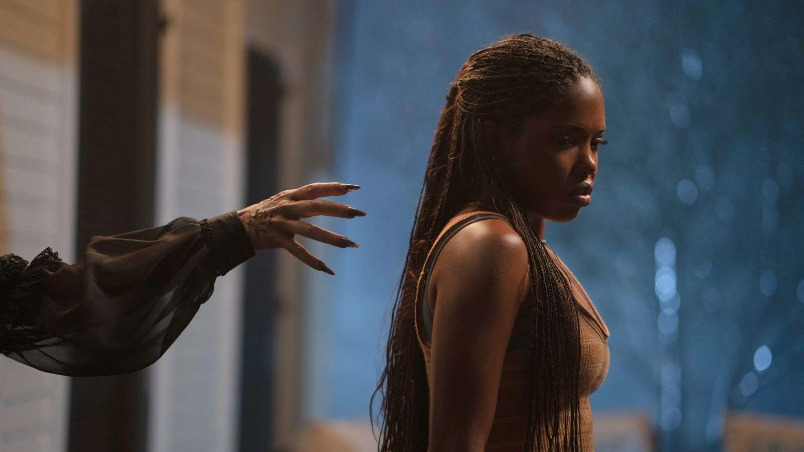 Ryan Destiny as Shay in Oracle, standing with a hand reaching out to her back