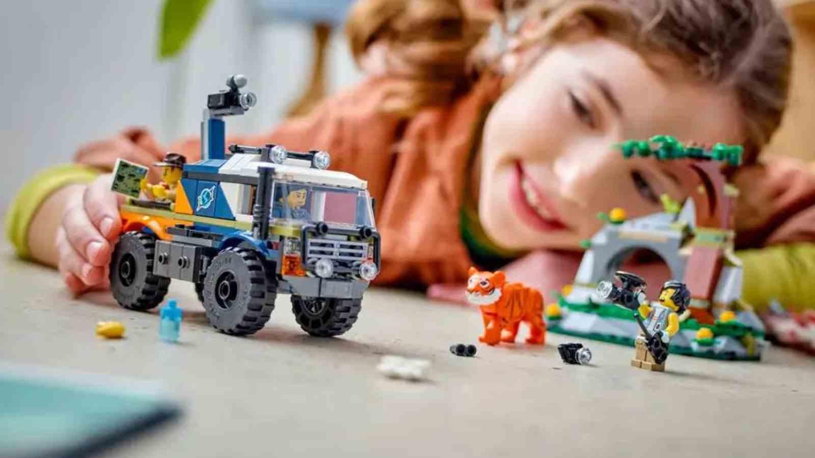 A child with their LEGO City Off-Road Truck