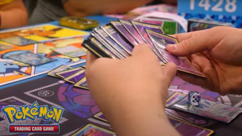A Pokemon TCG player holds out their deck