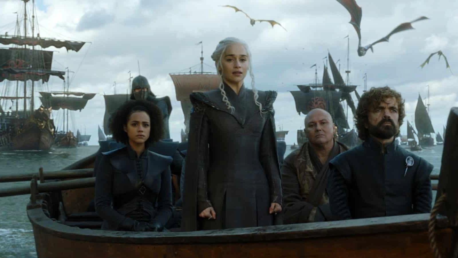 The cast of Game of Thrones on boat with dragons above