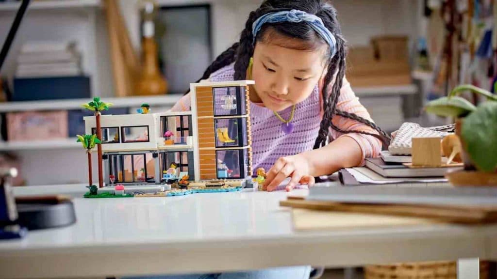 A child with their LEGO Creator 3in1 Modern House set
