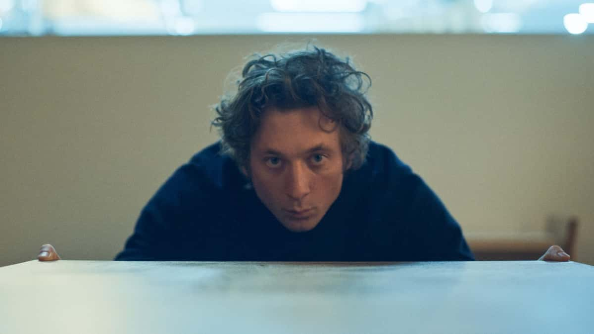 Jeremy Allen White looking across a table in The Bear.