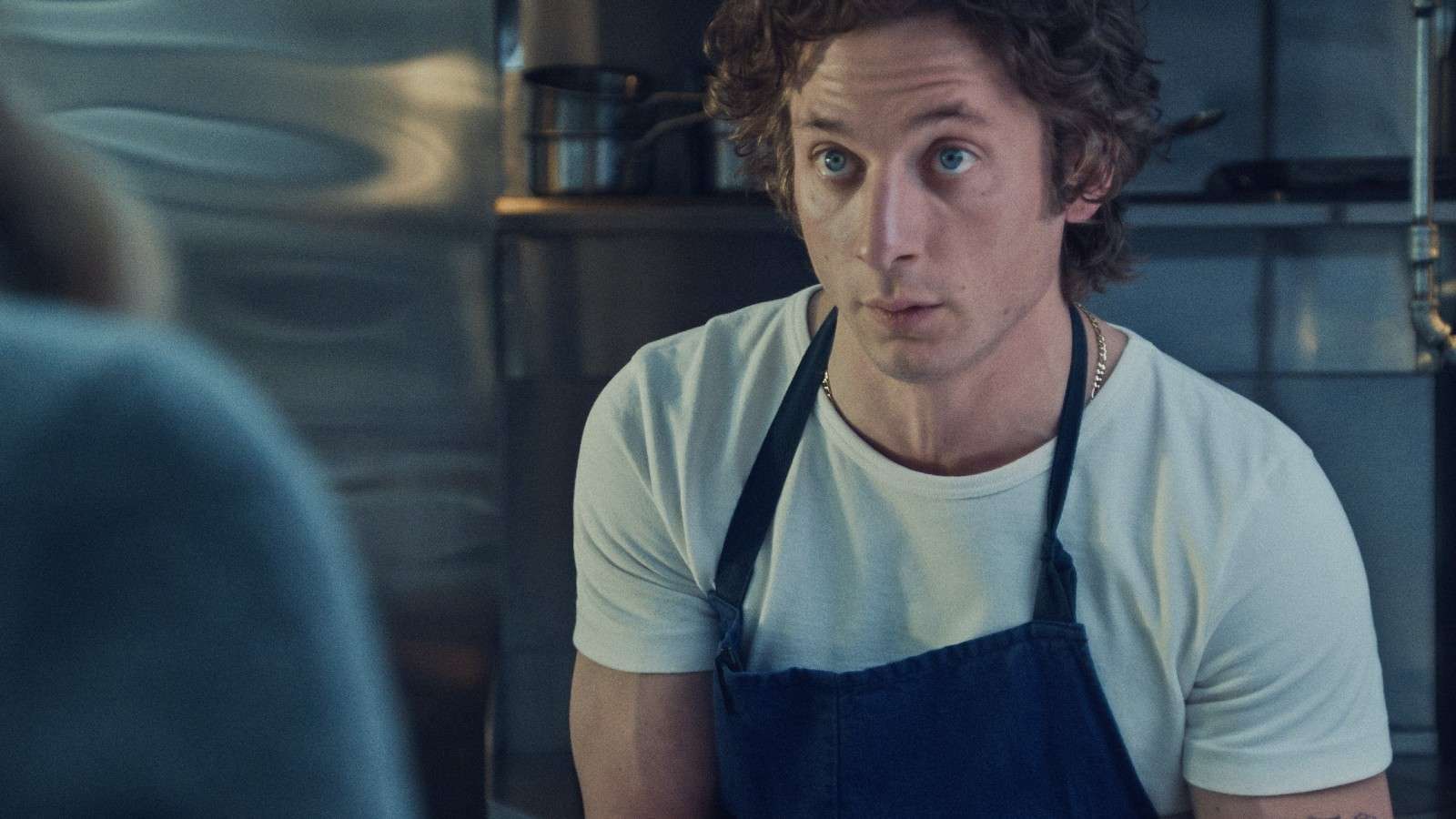 Jeremy Allen White as Carmy sitting in the kitchen in The Bear.