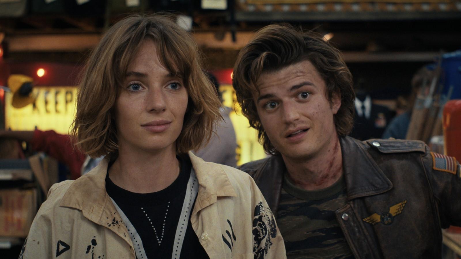 Maya Hawke and Joe Keery as Robin and Steve, covered in dirty and looking past the camera in Stranger Things