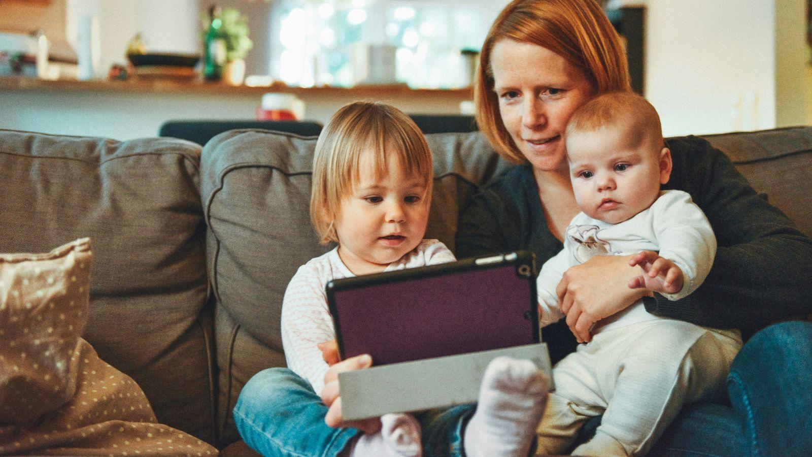 Mom and two children sitting with a tablet
