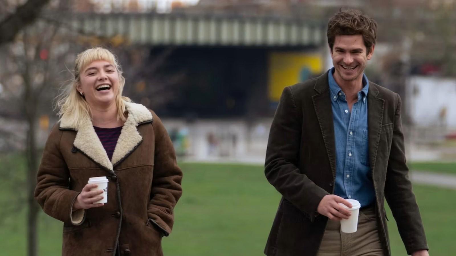 Florence Pugh and Andrew Garfield as Tobias and Almut in We Live in Time, walking through the park and laughing