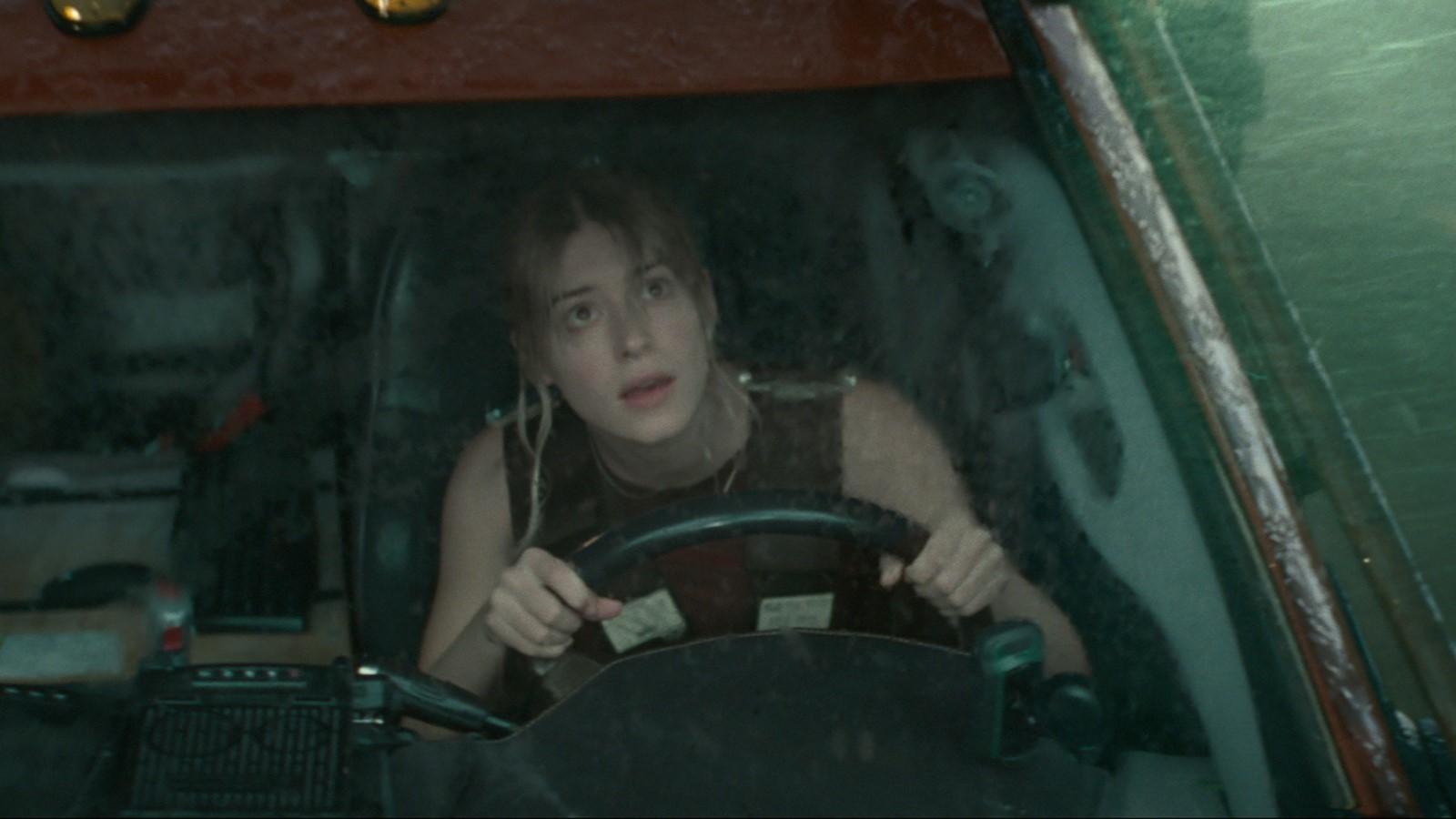 Daisy Edgar-Jones as Kate in Twisters, sitting in a car and looking up