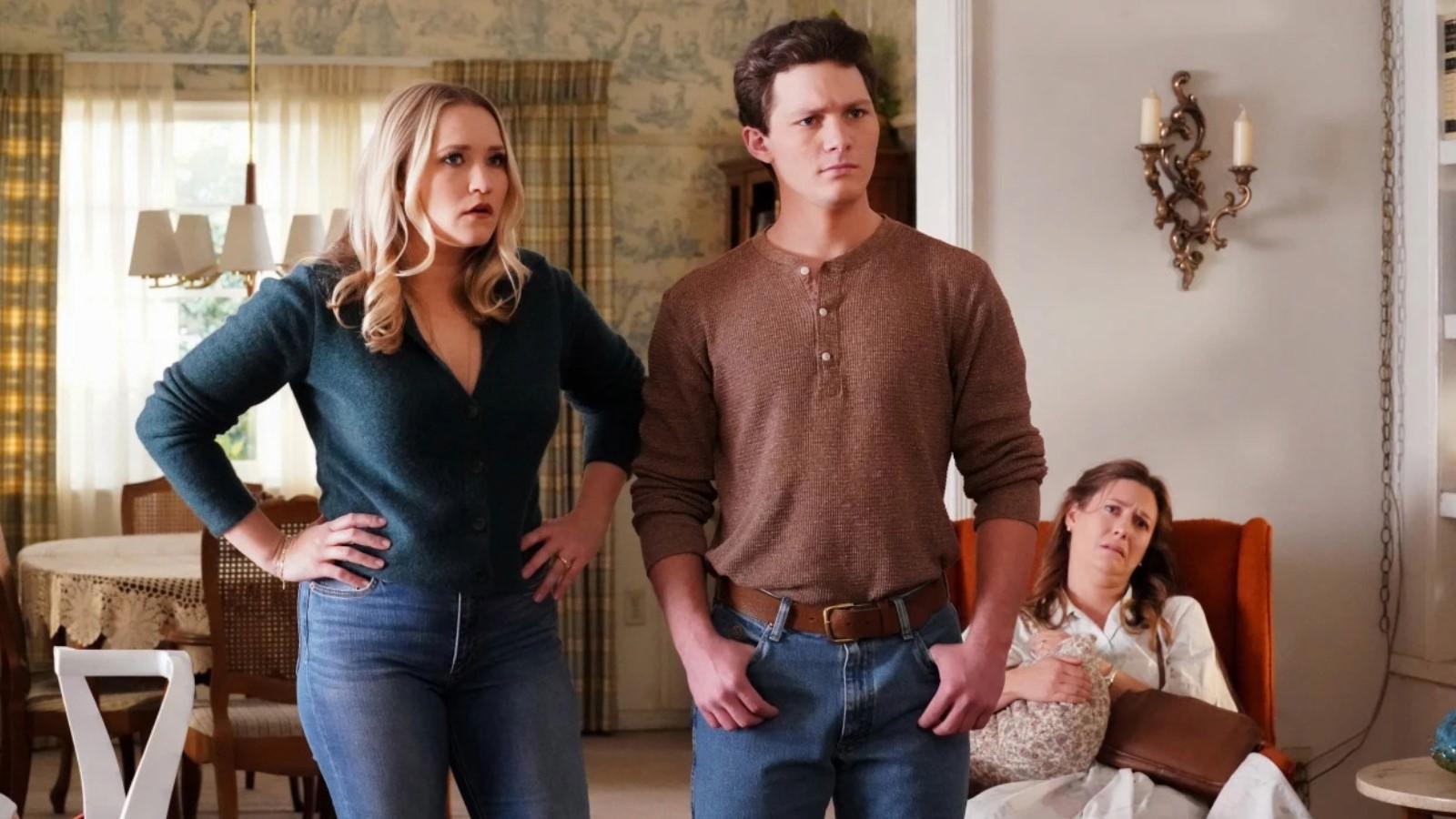 Emily Osment and Montana Jordan as Mandy and Georgie, standing up in the living room in Young Sheldon