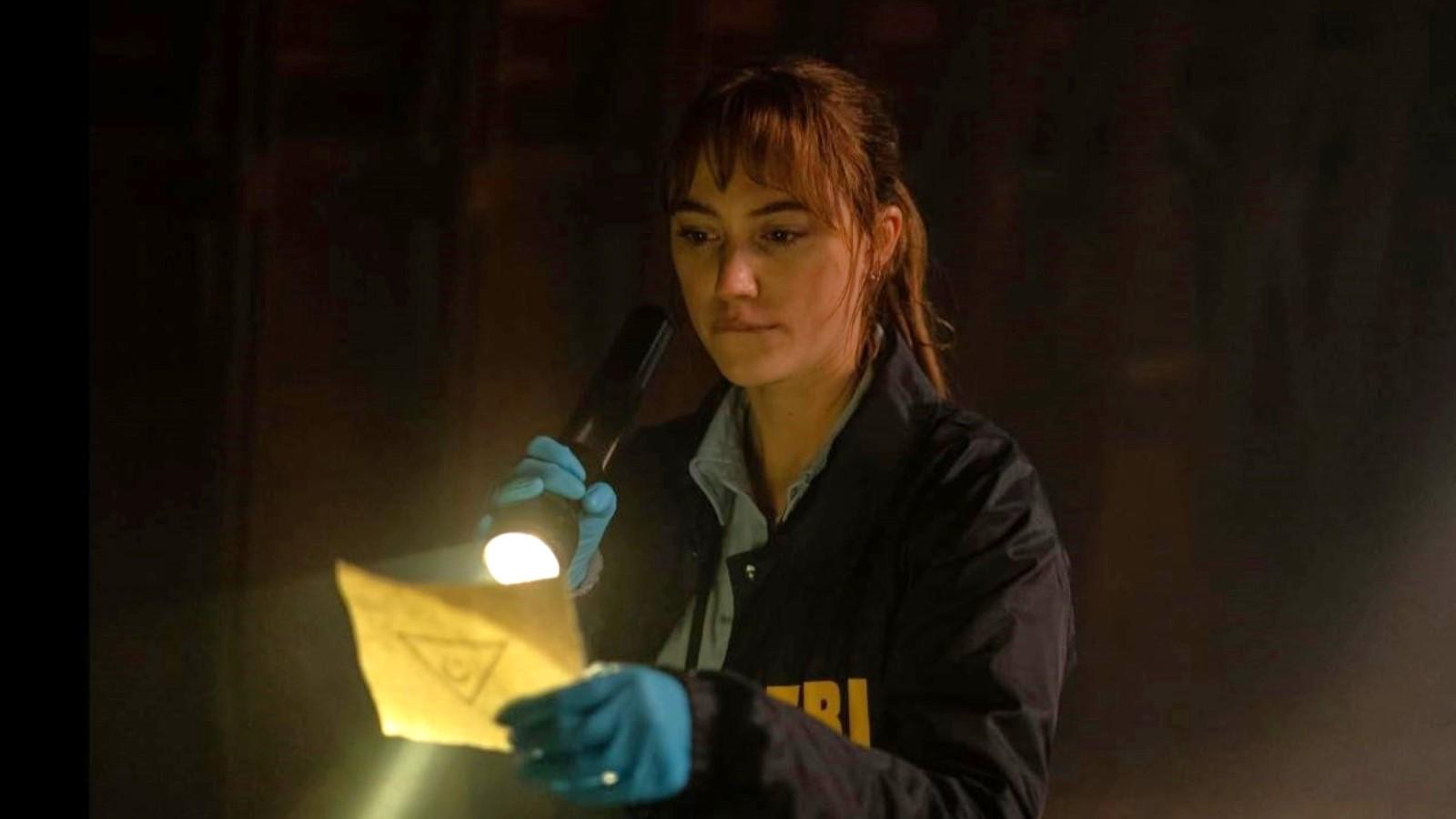 Why is he called Longlegs? Maika Monroe as Lee Harker, holding a flashlight to a piece of paper