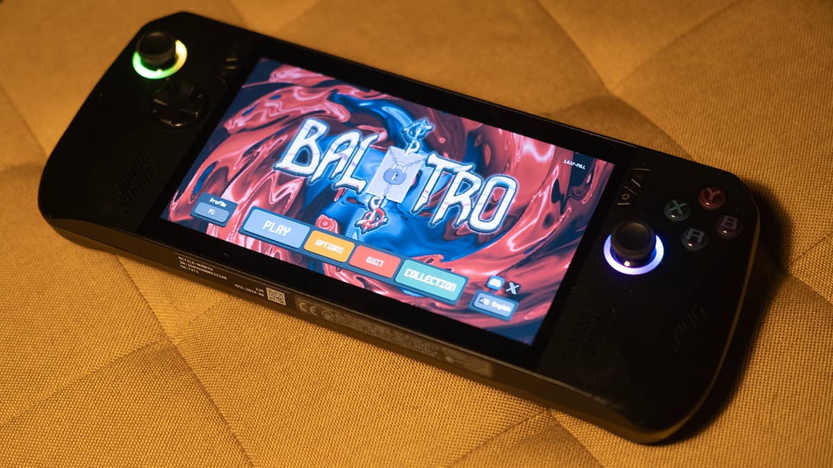 Asus ROG Ally X displaying Balatro on a yellow cushion surface