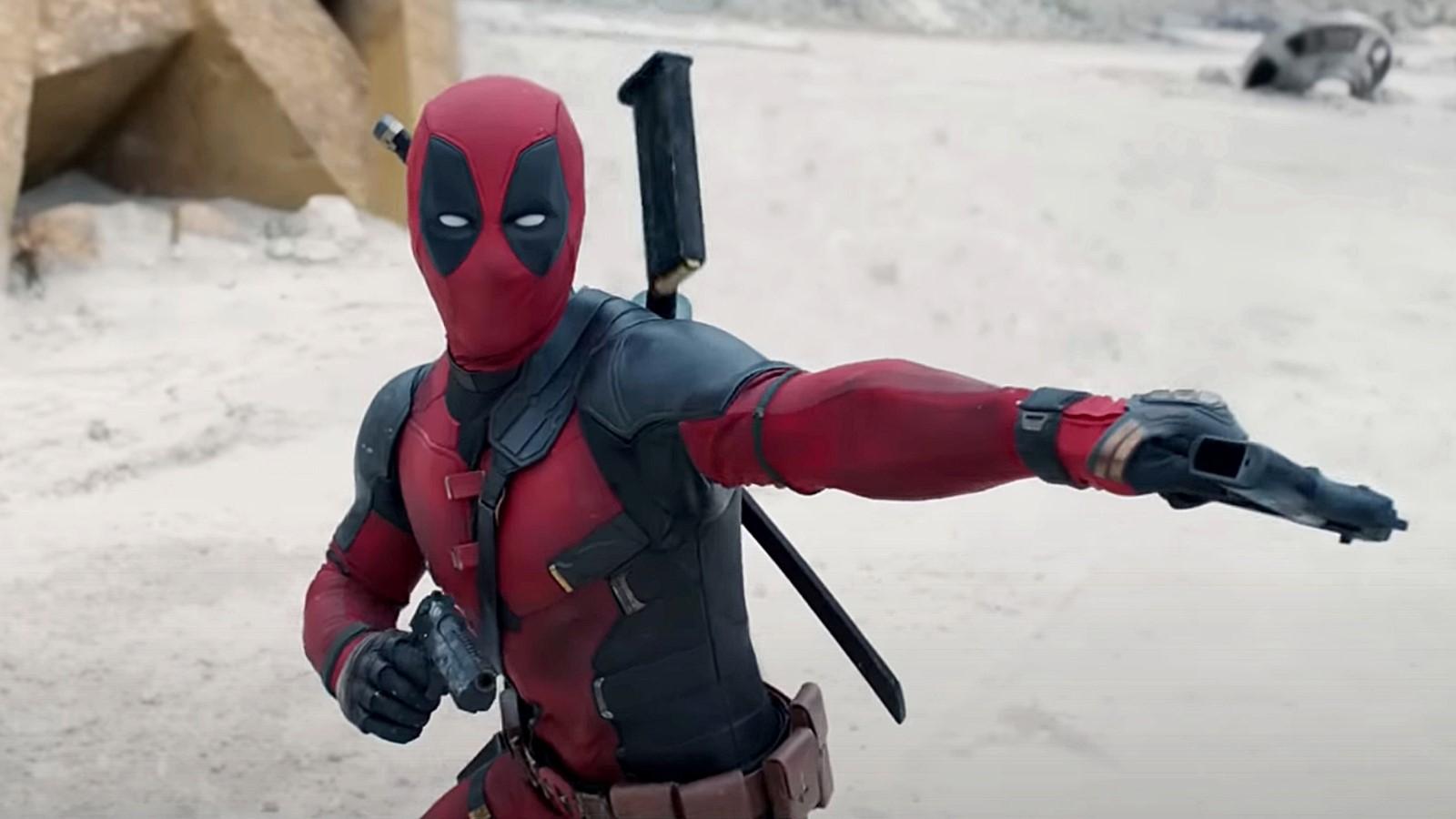 Ryan Reynolds as Deadpool, holding out a gun