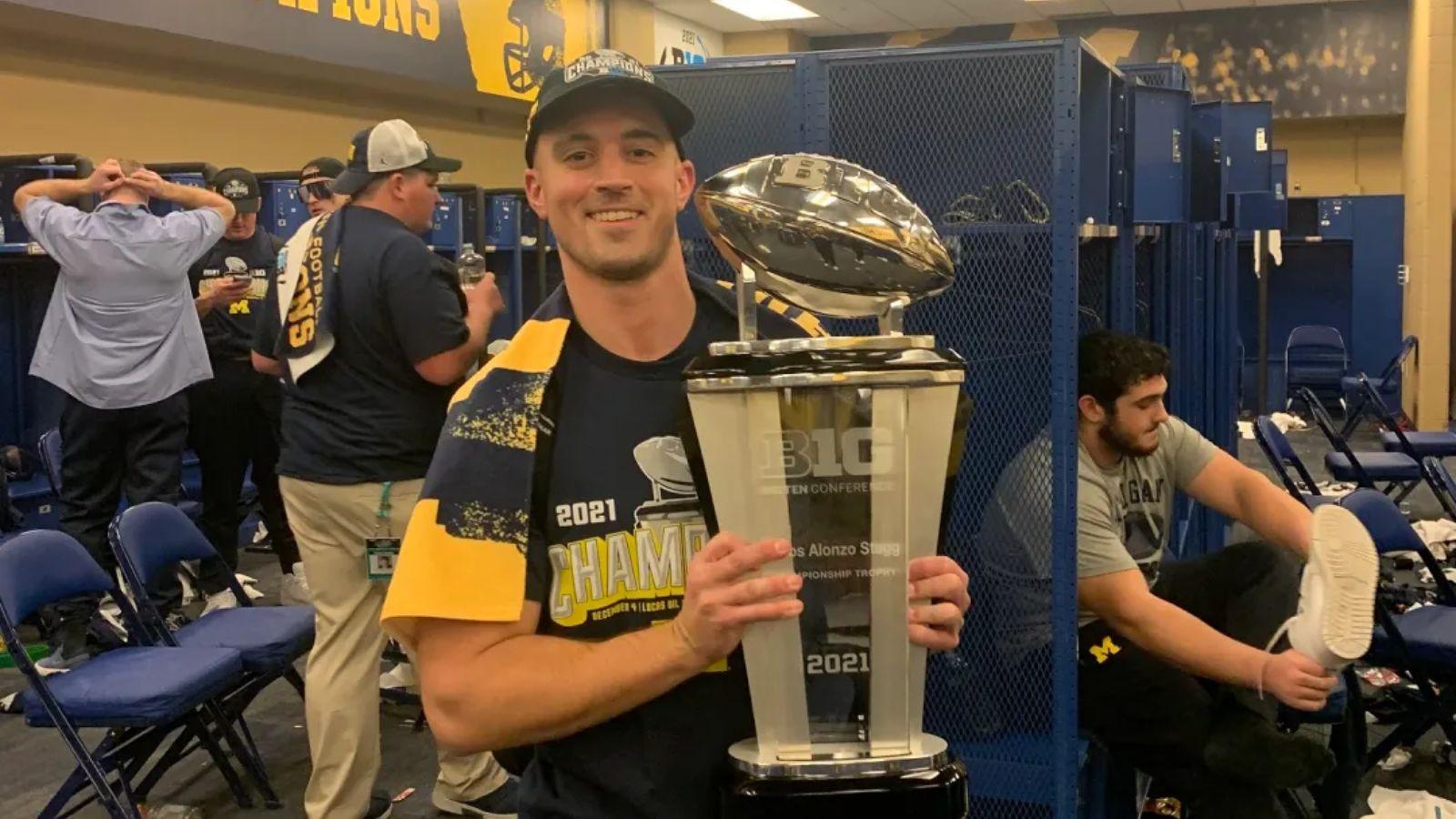 Connor Stalions celebrating holding the championship trophy.