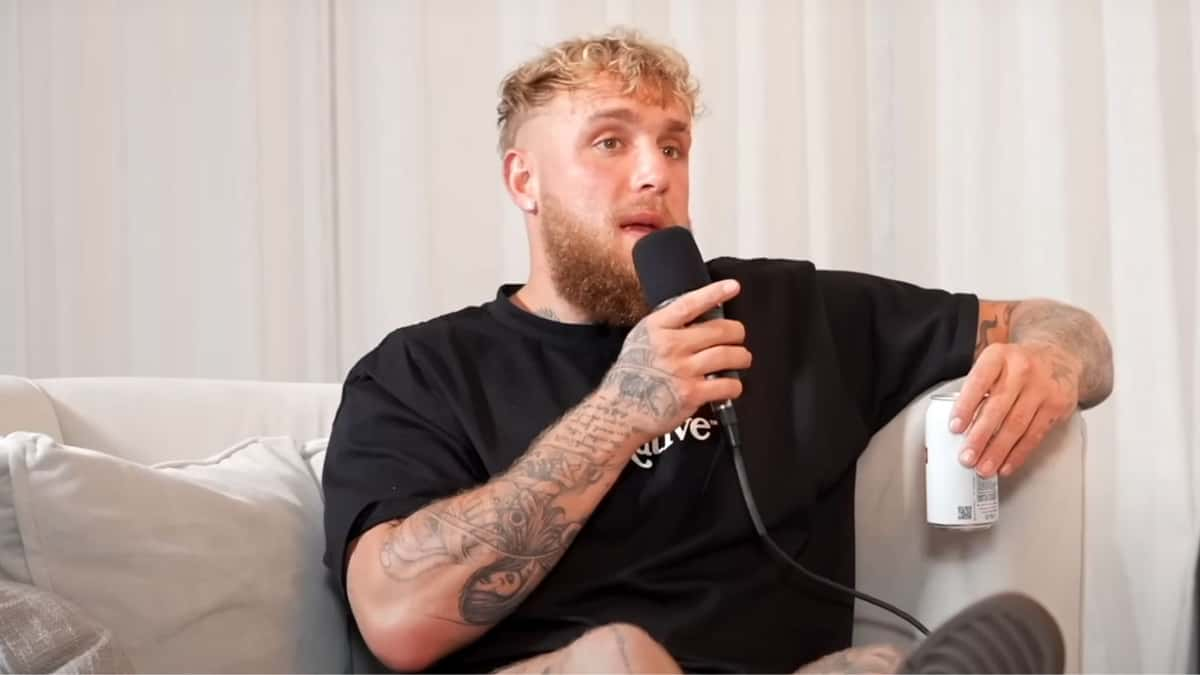 Jake Paul sat on couch holding mic and can while talking