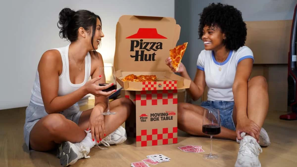 couple eating pizza hut pizza on the floor using a pizza hut box that turns into a table.