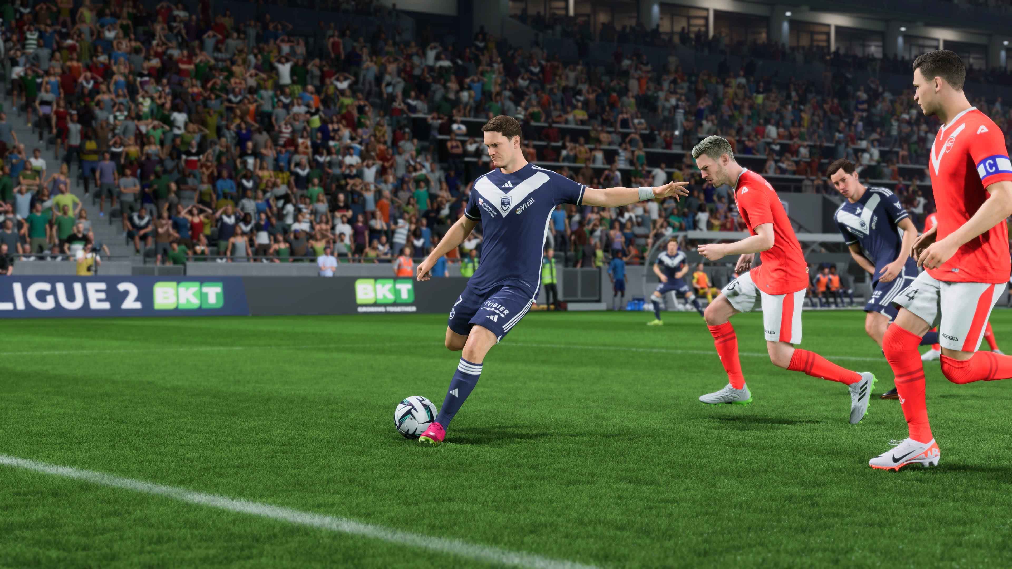 A Bordeaux player kicking the ball, wearing their navy home shirt.