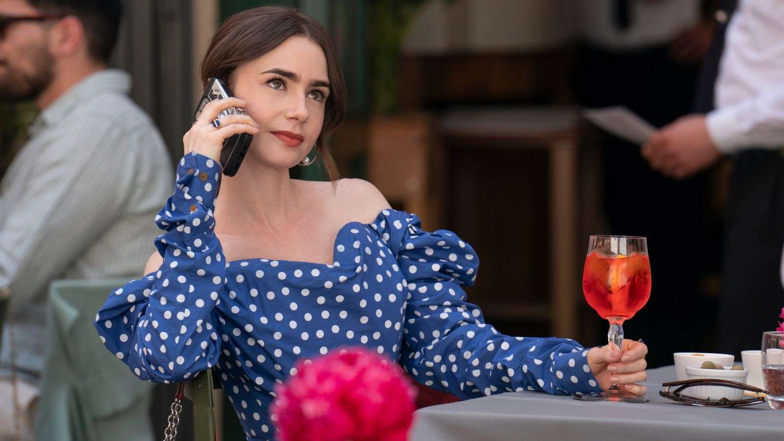 Emily on the phone with an aperol spritz in Emily in Paris Season 4 Part 2