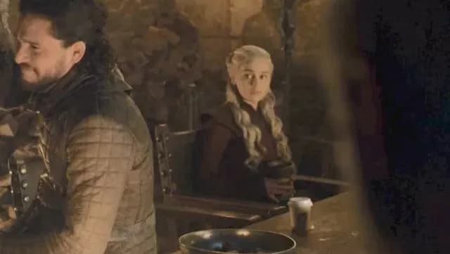 Emilia Clark in Game of Thrones with a coffee cup in front of her