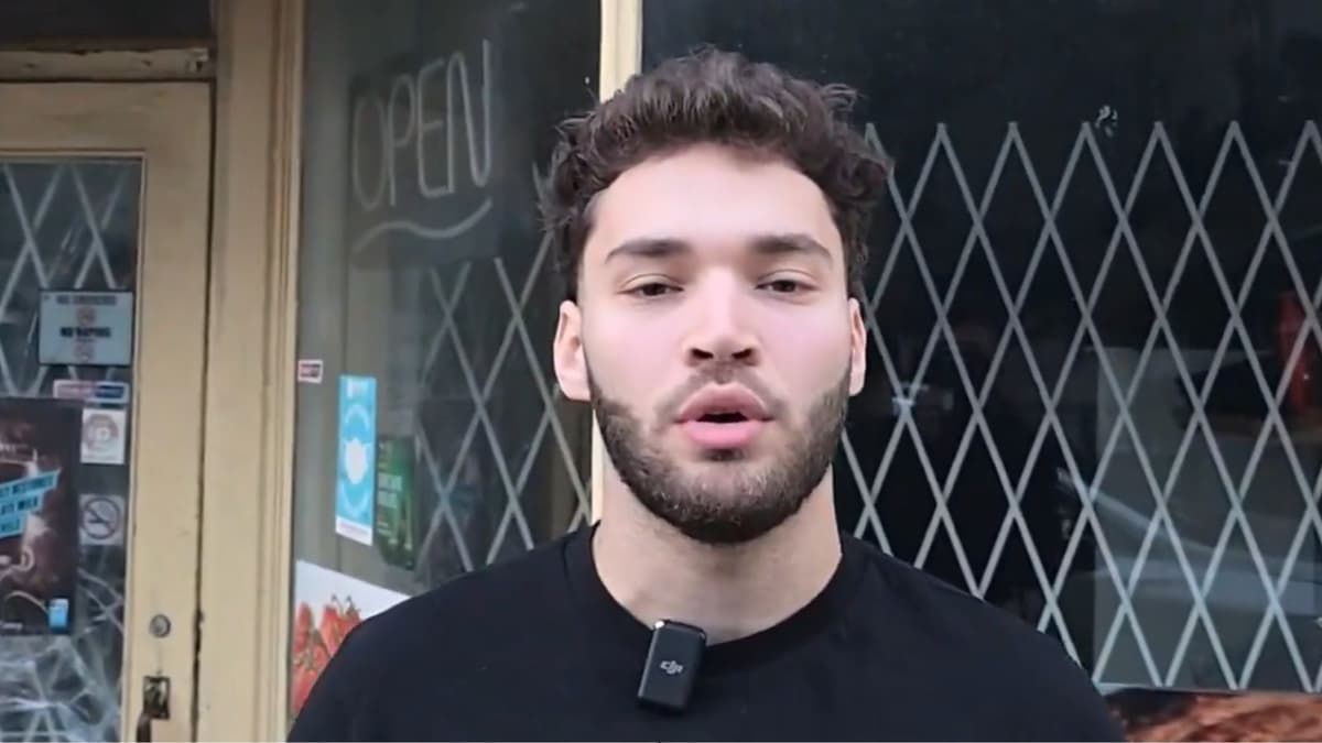 Adin Ross in black shirt talking to camera outside store